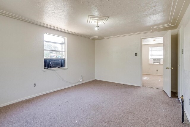 unfurnished room with carpet flooring, cooling unit, a textured ceiling, and ornamental molding