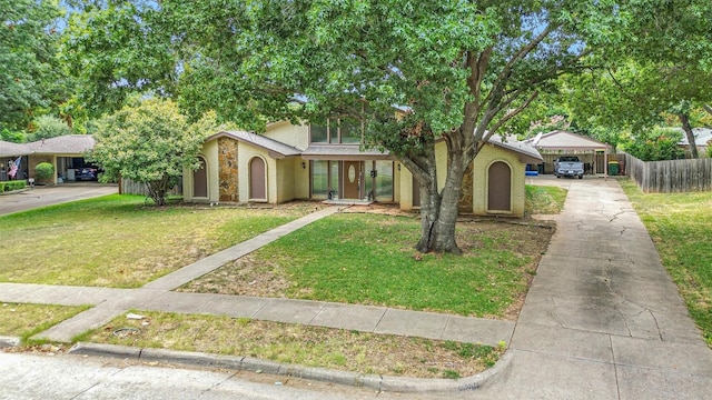 view of front of home with brick siding, fence, a front yard, a carport, and driveway
