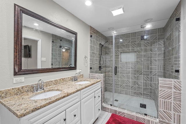 bathroom featuring tile patterned floors, a shower with door, and vanity