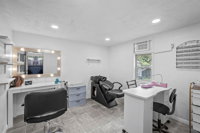 tiled office featuring a textured ceiling and a wall mounted AC