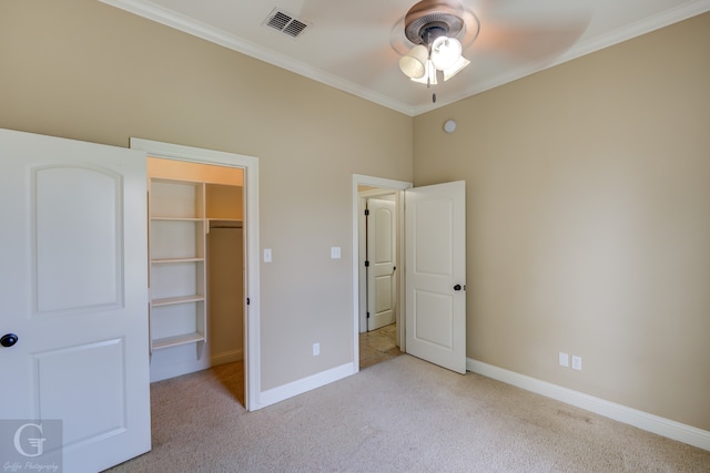 unfurnished bedroom featuring light carpet, a closet, ceiling fan, and crown molding