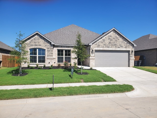 view of front of property featuring a garage and a front lawn