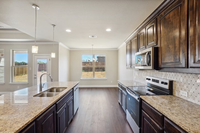 kitchen featuring dark brown cabinetry, appliances with stainless steel finishes, sink, and a wealth of natural light