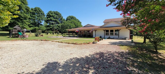 view of front of house featuring a front lawn and a playground