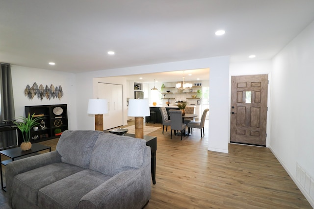 living room featuring wood-type flooring and a notable chandelier