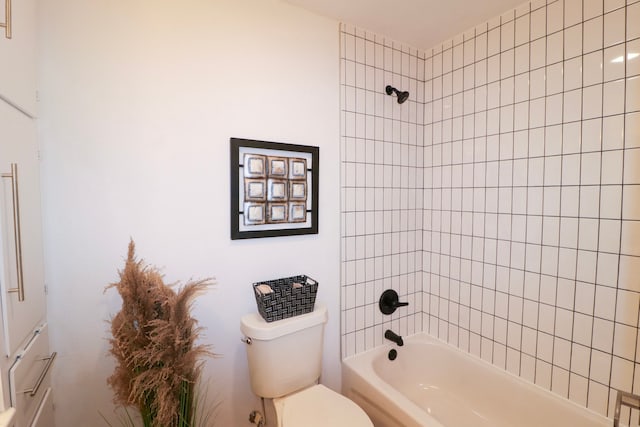 bathroom featuring toilet and tiled shower / bath