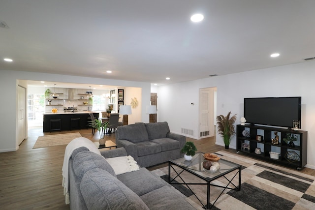 living room with light hardwood / wood-style flooring and an inviting chandelier