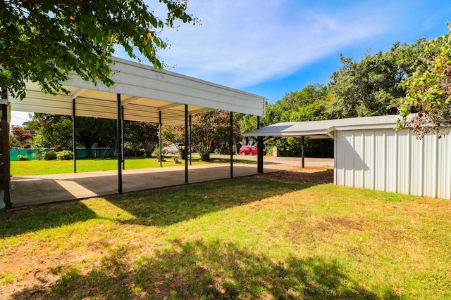 view of vehicle parking with a carport and a yard