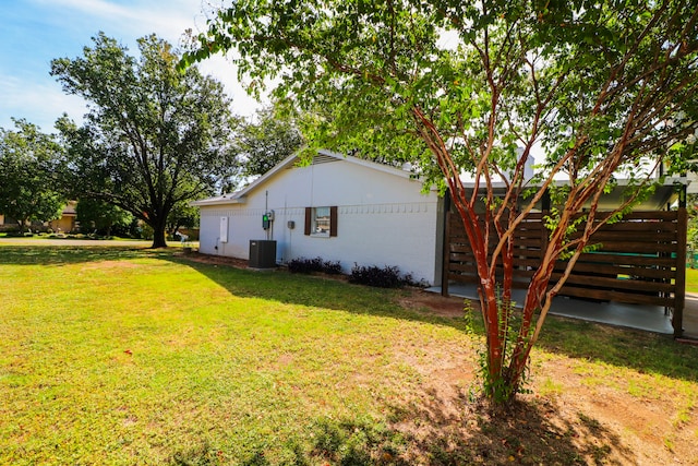 view of home's exterior featuring a lawn and central AC