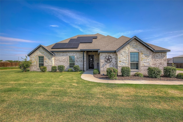 french country style house with solar panels and a front yard