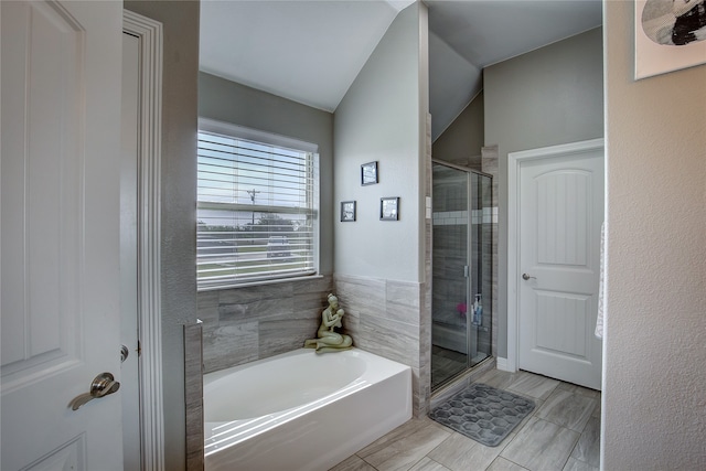 bathroom with vaulted ceiling, shower with separate bathtub, and tile patterned floors