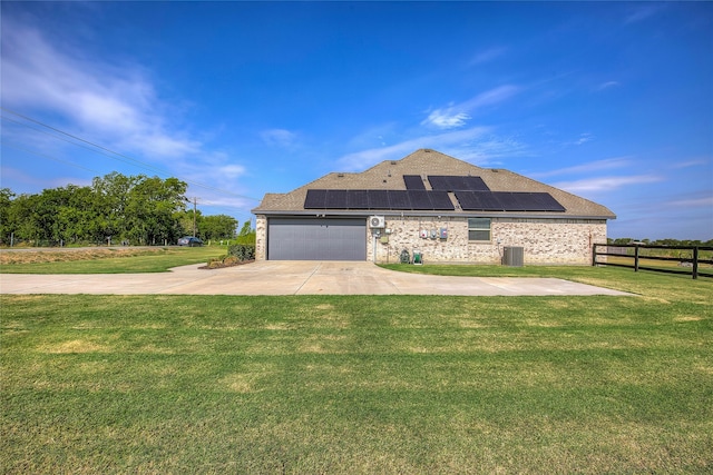 view of front facade featuring a front yard, solar panels, and a garage