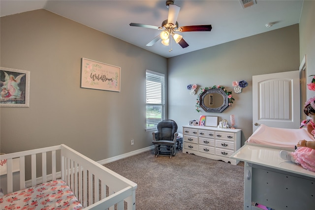 carpeted bedroom featuring ceiling fan, vaulted ceiling, and a nursery area