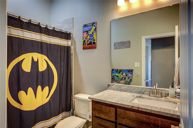 bathroom featuring curtained shower, vanity, and toilet