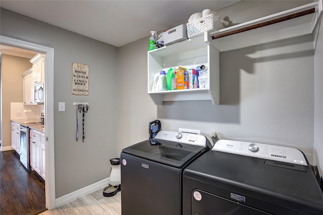 laundry room featuring dark wood-type flooring and separate washer and dryer