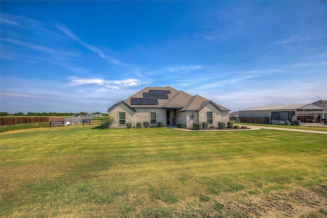 view of front of home with solar panels, a garage, and a front yard