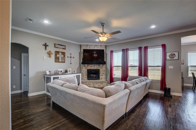 living room with a fireplace, ceiling fan, crown molding, and dark hardwood / wood-style floors