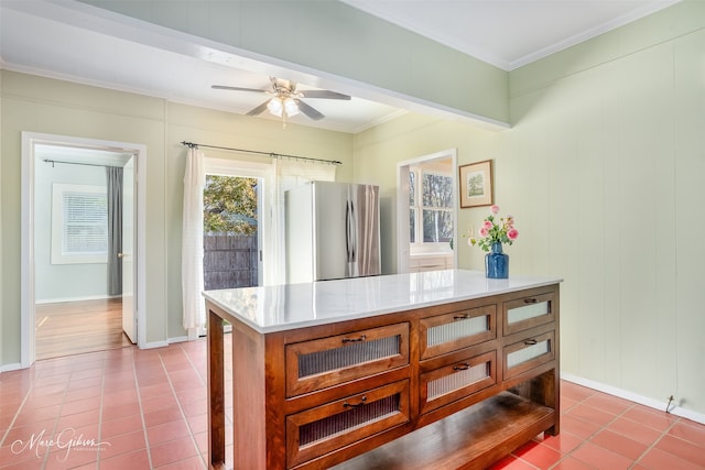 kitchen featuring stainless steel refrigerator, crown molding, light tile patterned floors, and ceiling fan