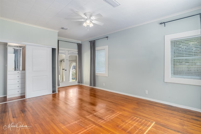 unfurnished bedroom with hardwood / wood-style floors, a closet, ceiling fan, and crown molding