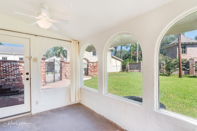 unfurnished sunroom featuring ceiling fan and vaulted ceiling