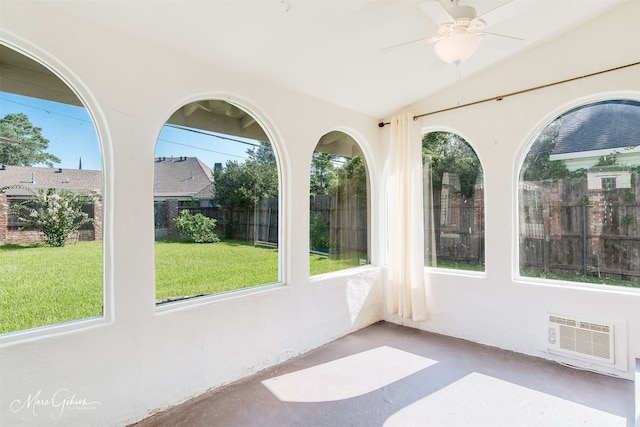 unfurnished sunroom featuring ceiling fan, a healthy amount of sunlight, and vaulted ceiling