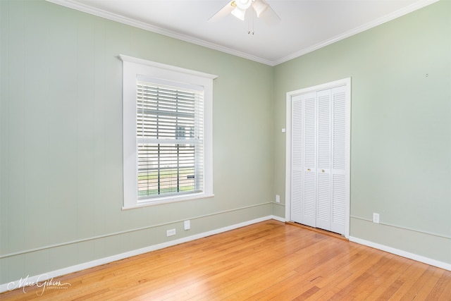 unfurnished bedroom featuring wood-type flooring, a closet, ceiling fan, and crown molding