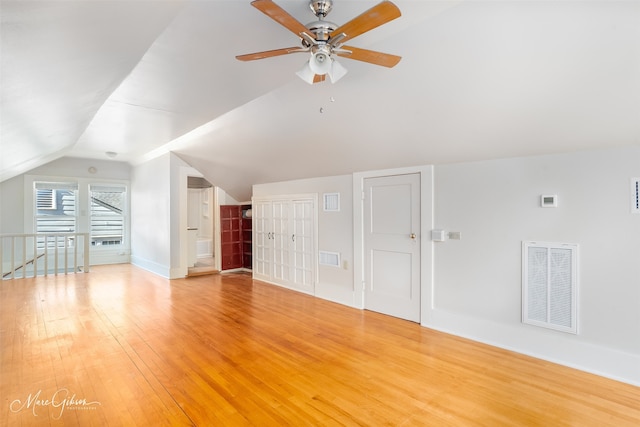 additional living space featuring hardwood / wood-style floors, vaulted ceiling, and ceiling fan