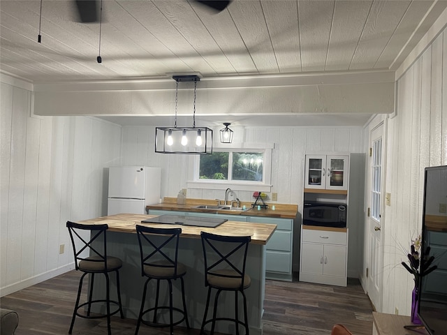 kitchen featuring sink, black appliances, dark hardwood / wood-style floors, and wooden counters