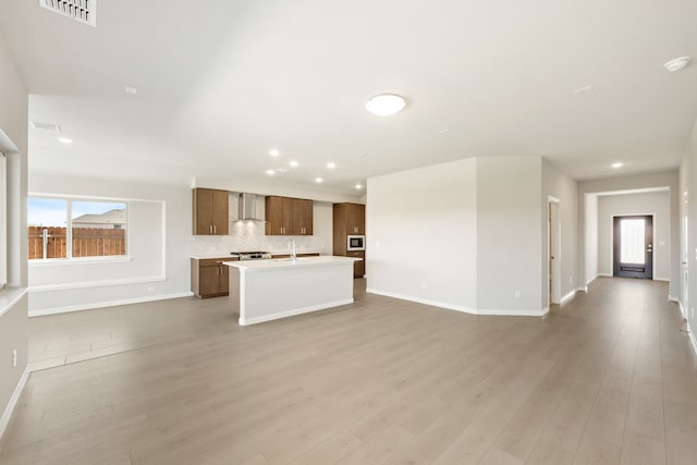 unfurnished living room featuring light wood-type flooring and sink