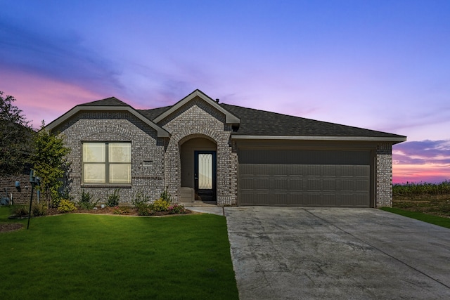 view of front of property featuring a yard and a garage