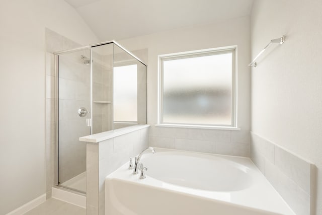 bathroom featuring lofted ceiling and independent shower and bath