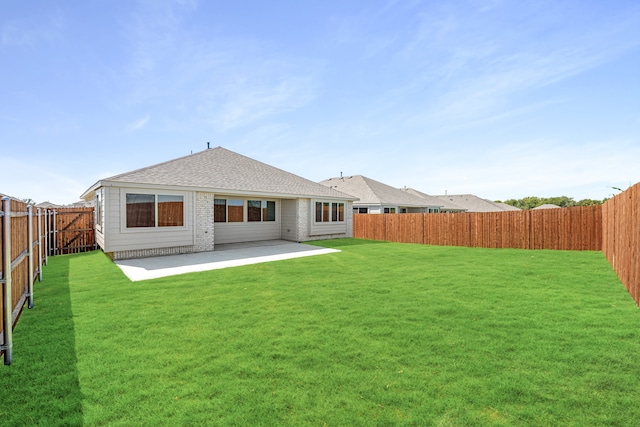 rear view of house featuring a patio area and a lawn