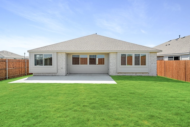 rear view of property featuring a lawn and a patio