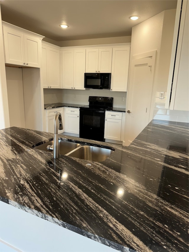 kitchen featuring sink, white cabinets, dark stone countertops, and black appliances