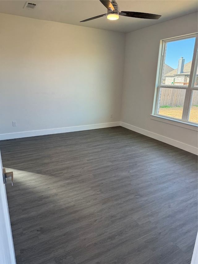 unfurnished room with ceiling fan and dark wood-type flooring