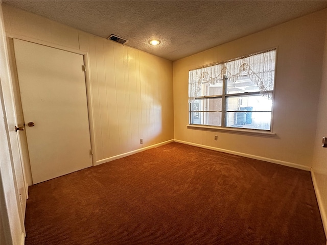 carpeted empty room with a textured ceiling