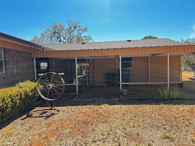 exterior space featuring roof with shingles and a sunroom