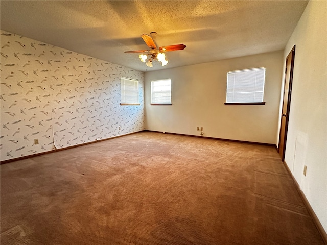 empty room featuring carpet flooring, ceiling fan, and a textured ceiling