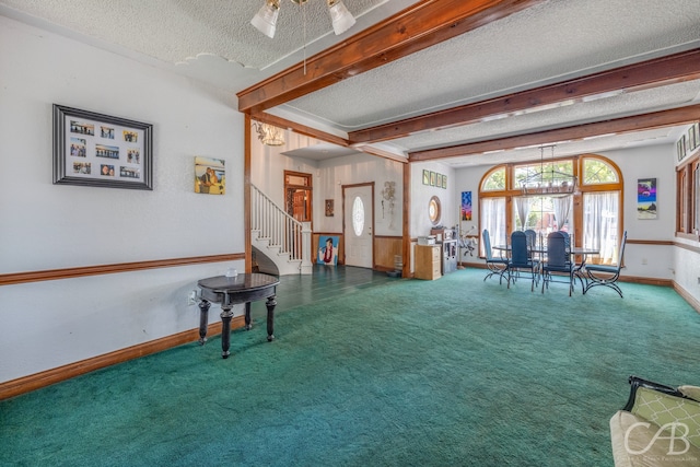 interior space featuring a textured ceiling, carpet floors, ceiling fan, and beam ceiling