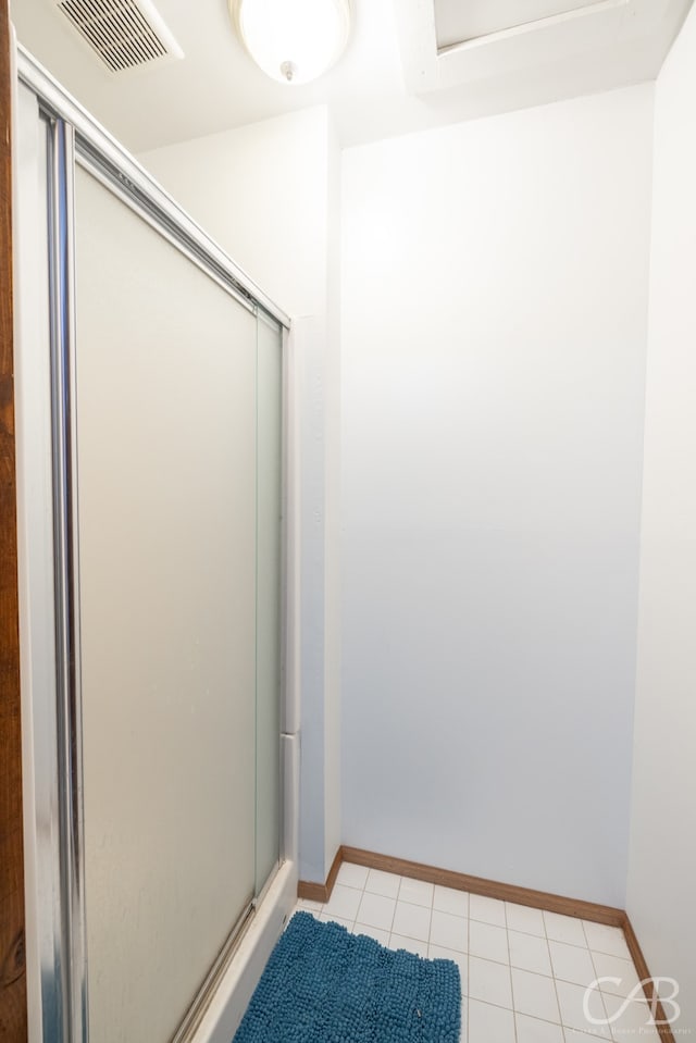 bathroom featuring tile patterned flooring and an enclosed shower