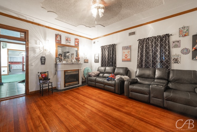 living room featuring hardwood / wood-style flooring, a textured ceiling, and ceiling fan