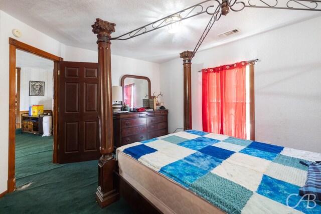 bedroom with dark colored carpet and a textured ceiling