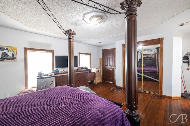 bedroom with a textured ceiling, a closet, and dark hardwood / wood-style floors