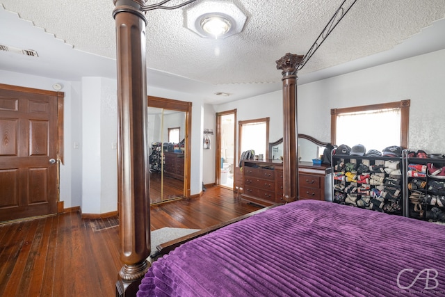 bedroom featuring a textured ceiling, a closet, decorative columns, and dark hardwood / wood-style floors