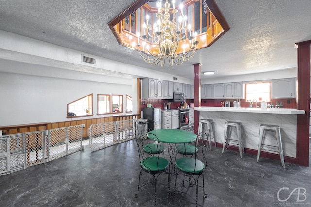 dining room featuring a textured ceiling and a chandelier