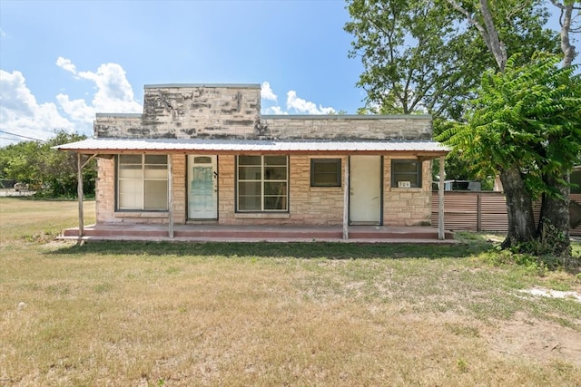 back of property featuring covered porch and a yard