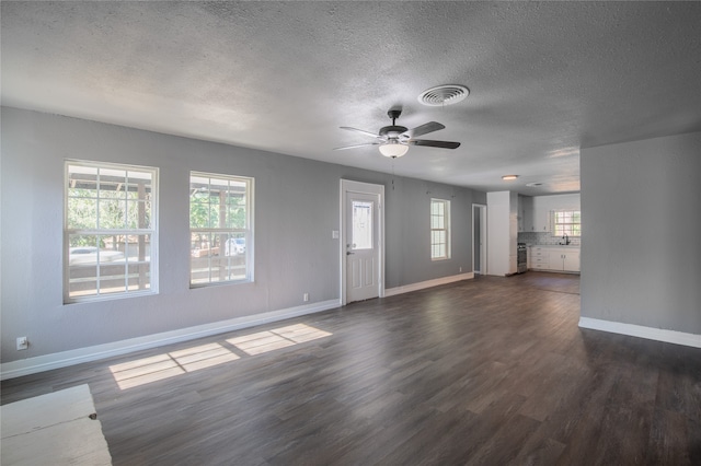 unfurnished living room featuring ceiling fan, sink, a textured ceiling, and dark hardwood / wood-style flooring