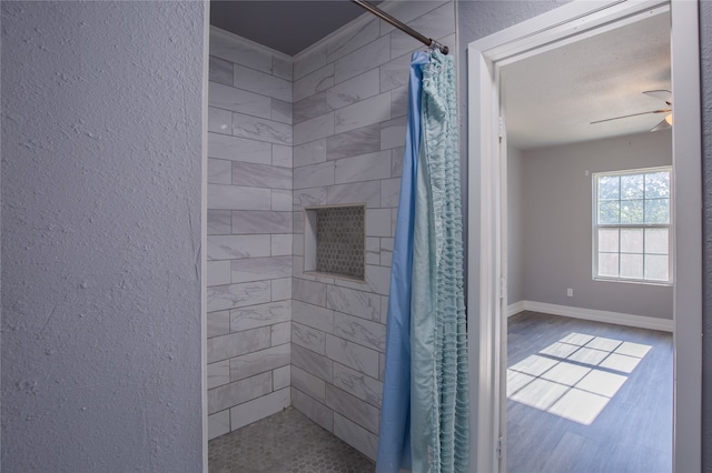 bathroom with ceiling fan, a textured ceiling, and a shower with shower curtain