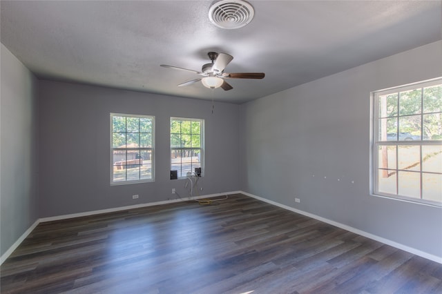 empty room with ceiling fan, a healthy amount of sunlight, and wood-type flooring