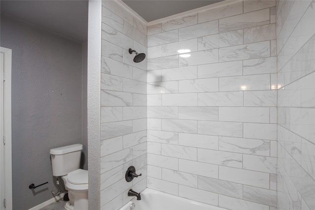 bathroom featuring toilet and tiled shower / bath combo